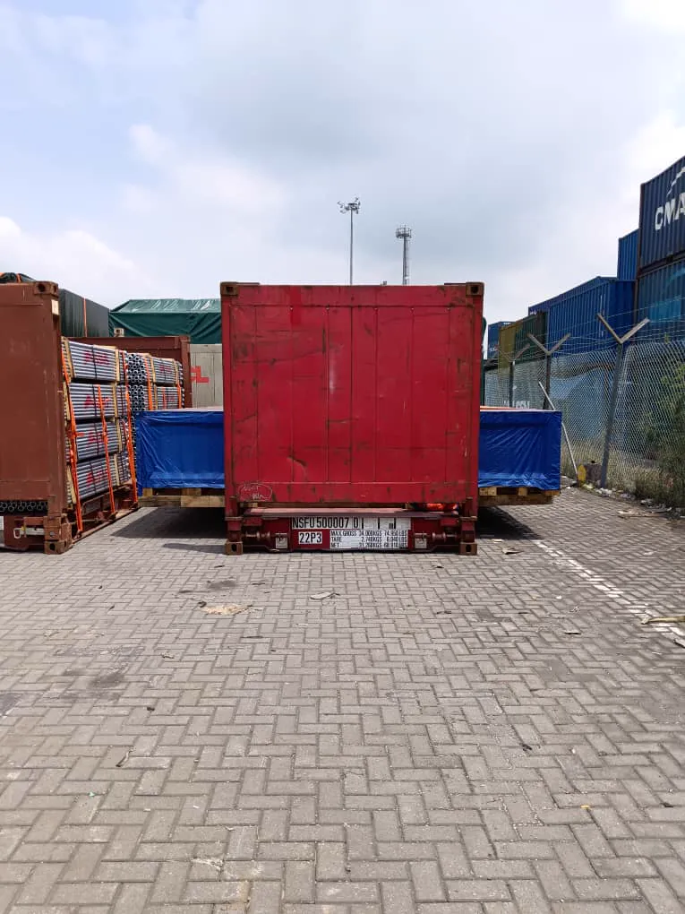 Containers loaded on flatbed trailers in a paved container yard.